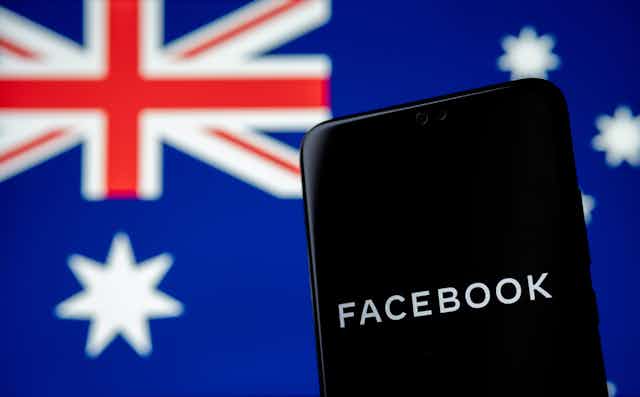 A phone with Facebook written on it in front of an Australian flag