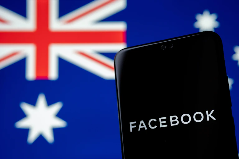 A phone with Facebook written on it in front of an Australian flag