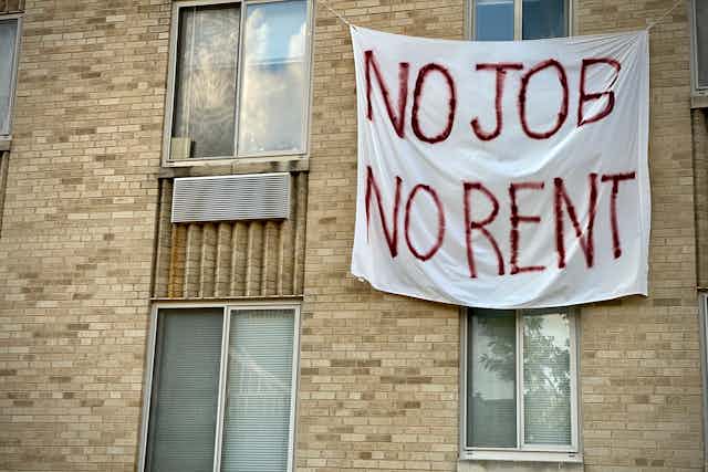 A banner on an apartment building that reads "No job, no rent."
