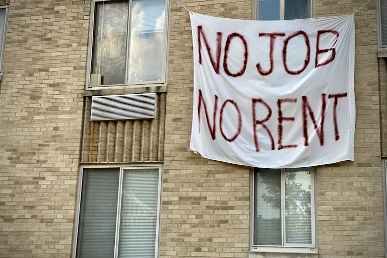 A banner on an apartment building that reads "No job, no rent."