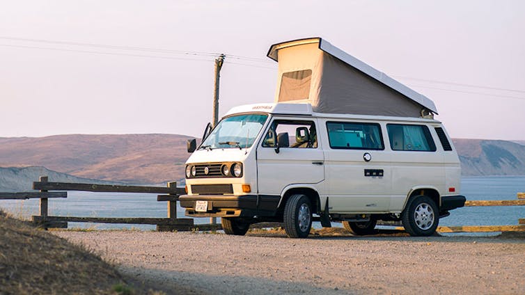 A campervan parked up with the roof extended.