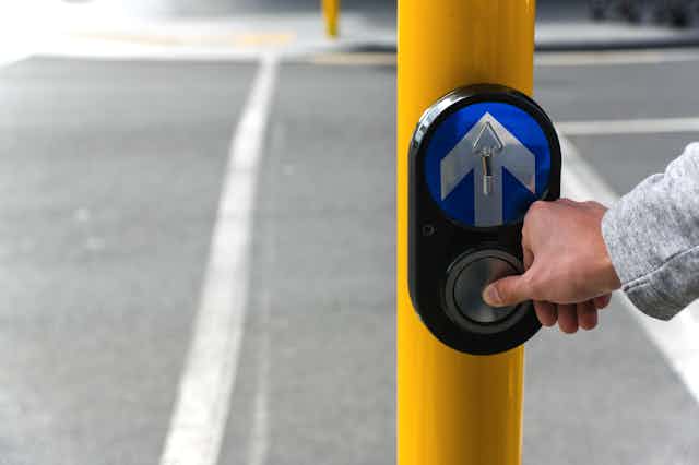 Person pressing button at traffic lights