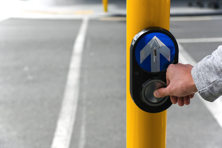 Person pressing button at traffic lights
