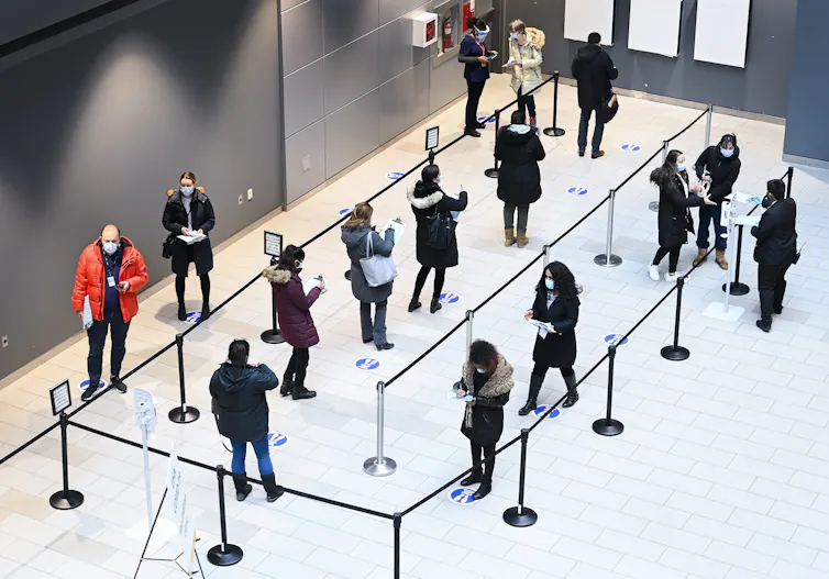 Shot from above of people waiting in line 6 feet apart