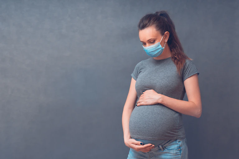Pregnant woman wearing a mask.