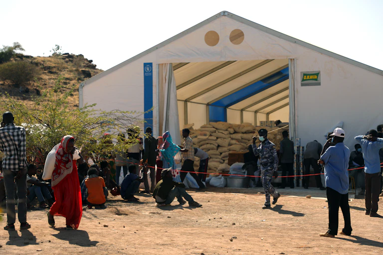 Men, women and humanitarian workers congregated at a food warehouse