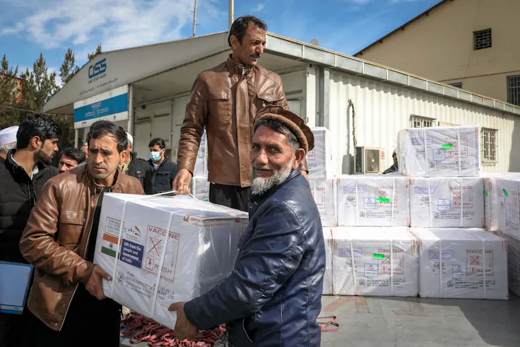 Men loading cartons of AstraZeneca vaccines on to a lorry at Kabul airport in Afghanistan, February 2021.