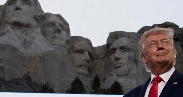 Trump smiles at Mount Rushmore.