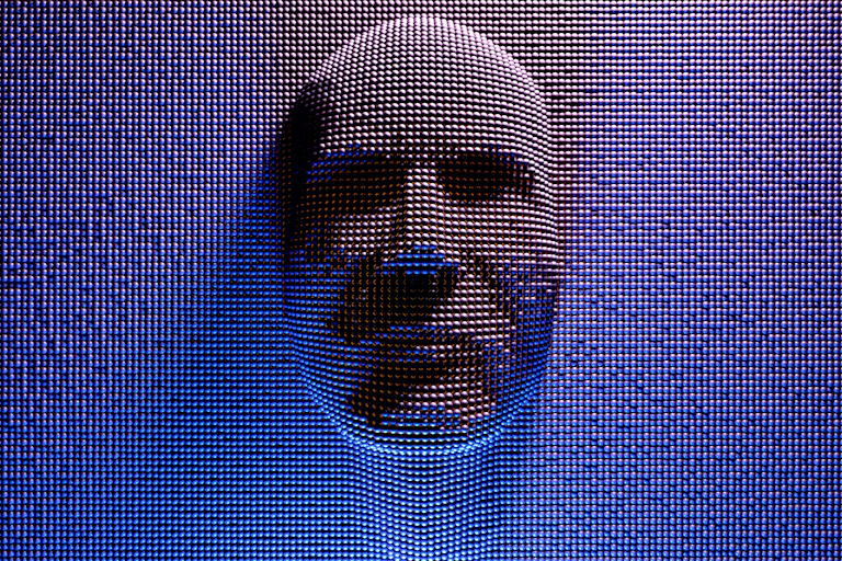 A man's face pushes through ball bearings