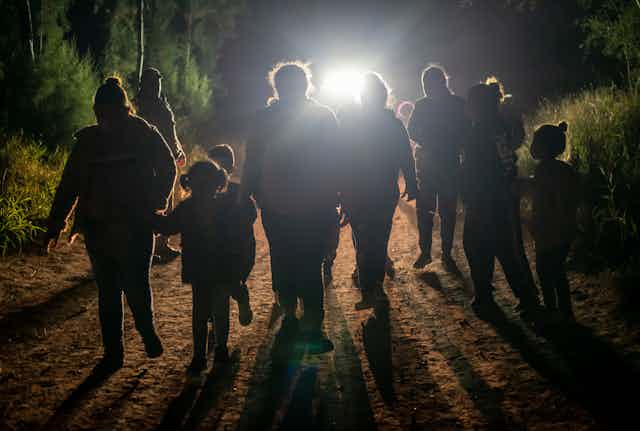 A group of people -- adults and children -- after being apprehended trying to cross into the US near Mission, Texas.