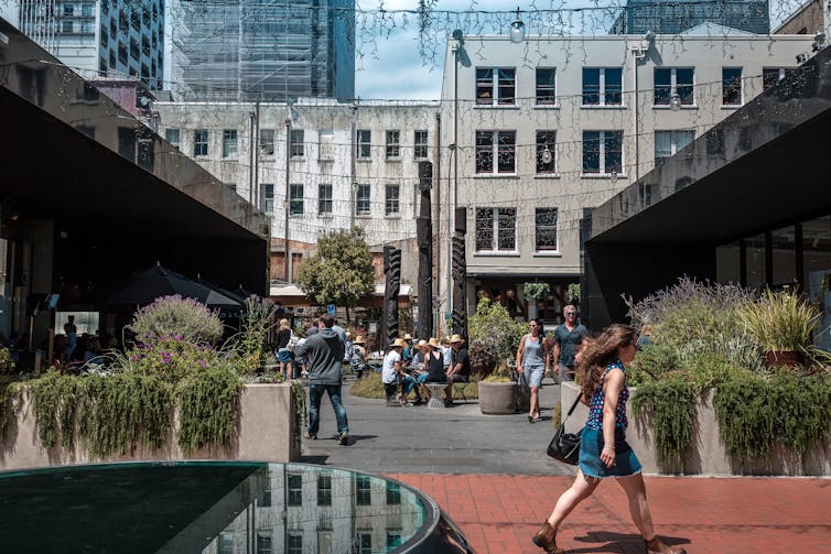 People walking in Auckland's Takutai Square.