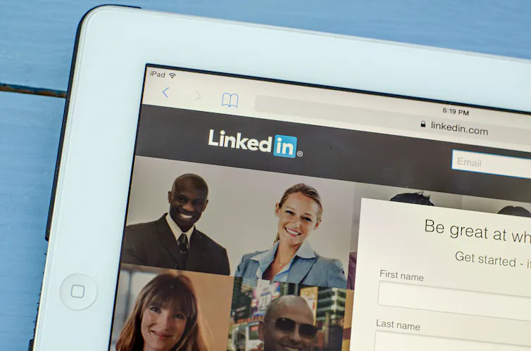 A computer displays the homepage of LinkedIn.