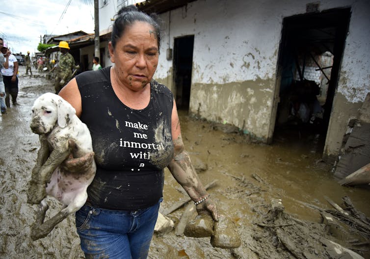 WOman walks through floodwaters with dog