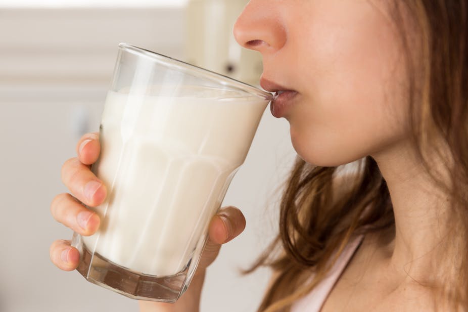 Woman drinking a glass of milk.
