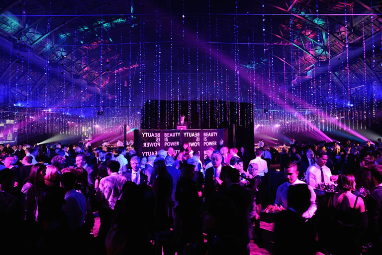 Partygoers mingling and eating hors d'oeuvres at a fancy ball