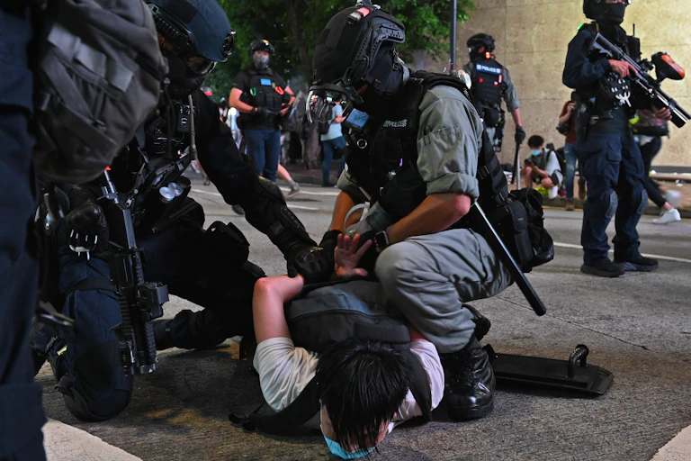 Police handcuff a man lying on the floor in Hong Kong.