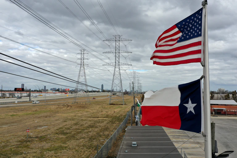 Texas and US flags fly near transmissions linees.