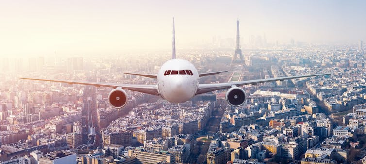 Plane flying over Paris, with eiffel tower in the background