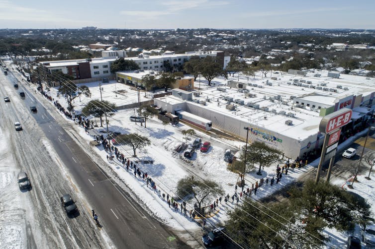 Aerial view of a long line to buy groceries in the snow