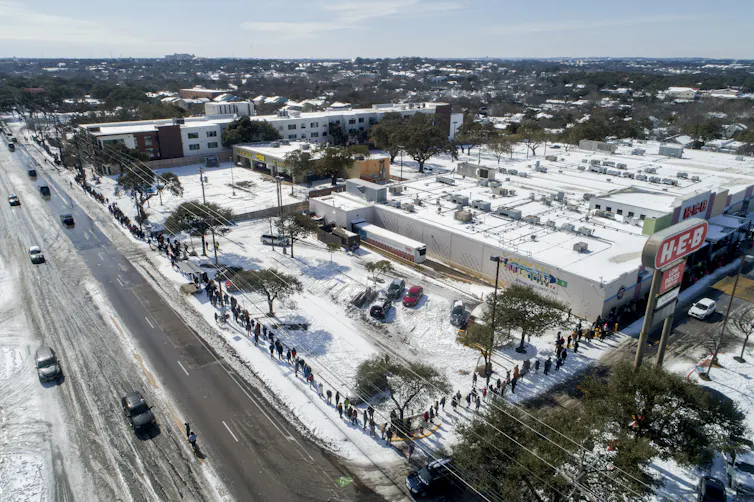 Aerial view of a long line to buy groceries in the snow