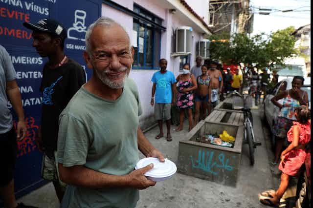 A man smiles after receiving a meal from a food bank in Rio de Janeiro, Brazil, October 2020.
