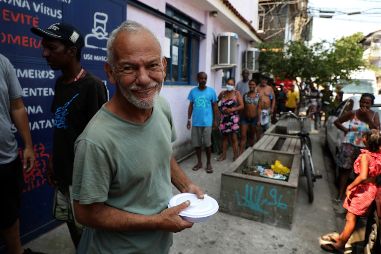 A man smiles after receiving a meal from a food bank in Rio de Janeiro, Brazil, October 2020.
