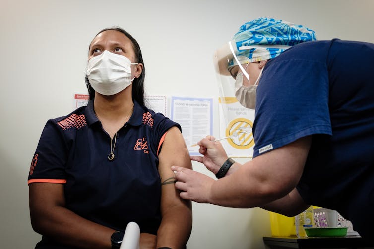 A border worker receiving a dose of the COVID-19 vaccine