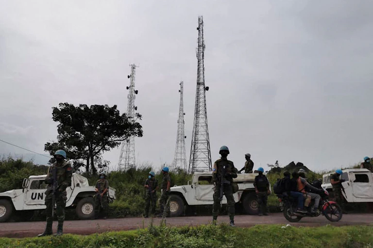 UN vehicles and uniformed men on a road