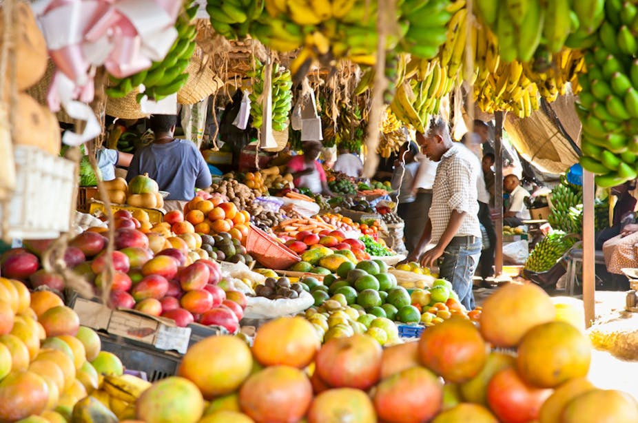 Homme sur un marché regardant des fruits frais.
