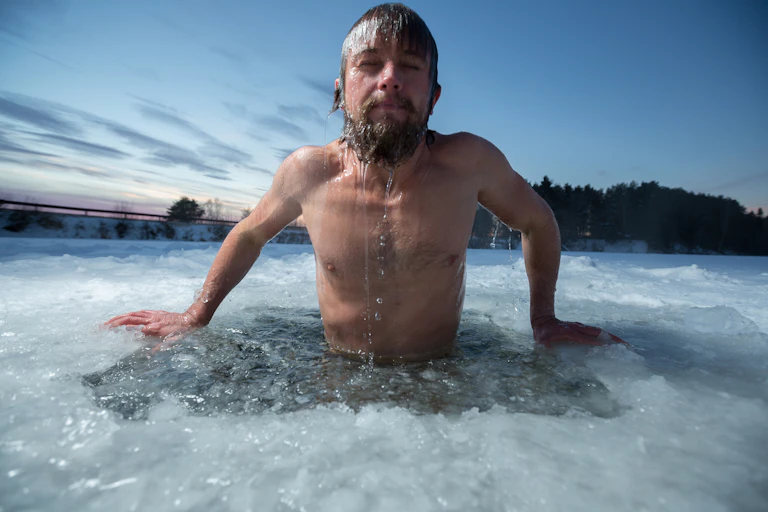 Man emerging from icy water.