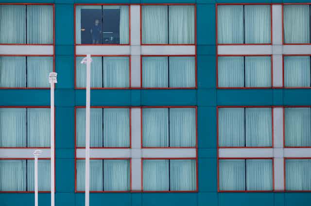 A man stands at a hotel window