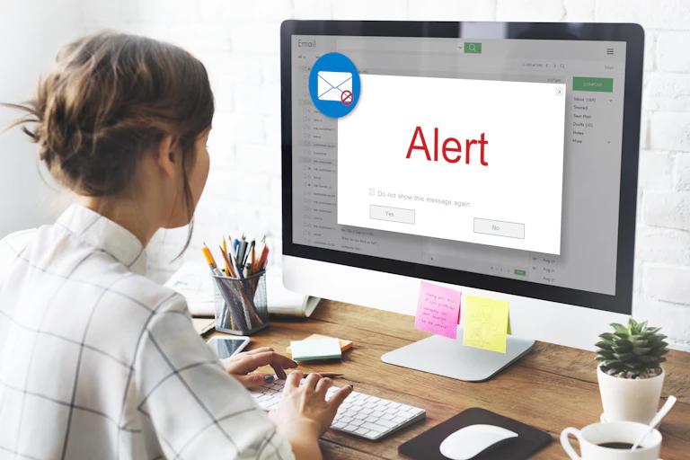 woman looking at laptop screen showing an email alert