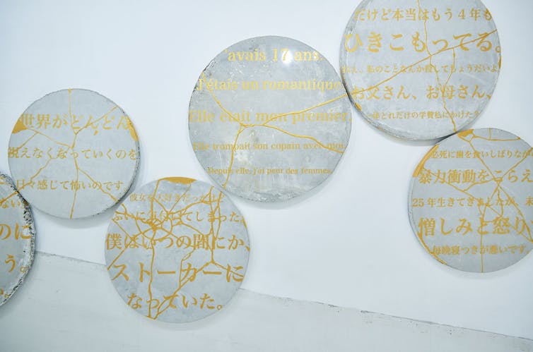 Broken plates with gold writing that have been put back togther.