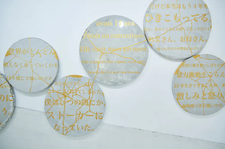Broken plates with gold writing that have been put back togther.