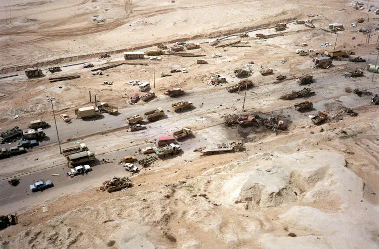 Aerial photograph of dozens of Iraqi tanks and military equipment destroyed or abandoned.