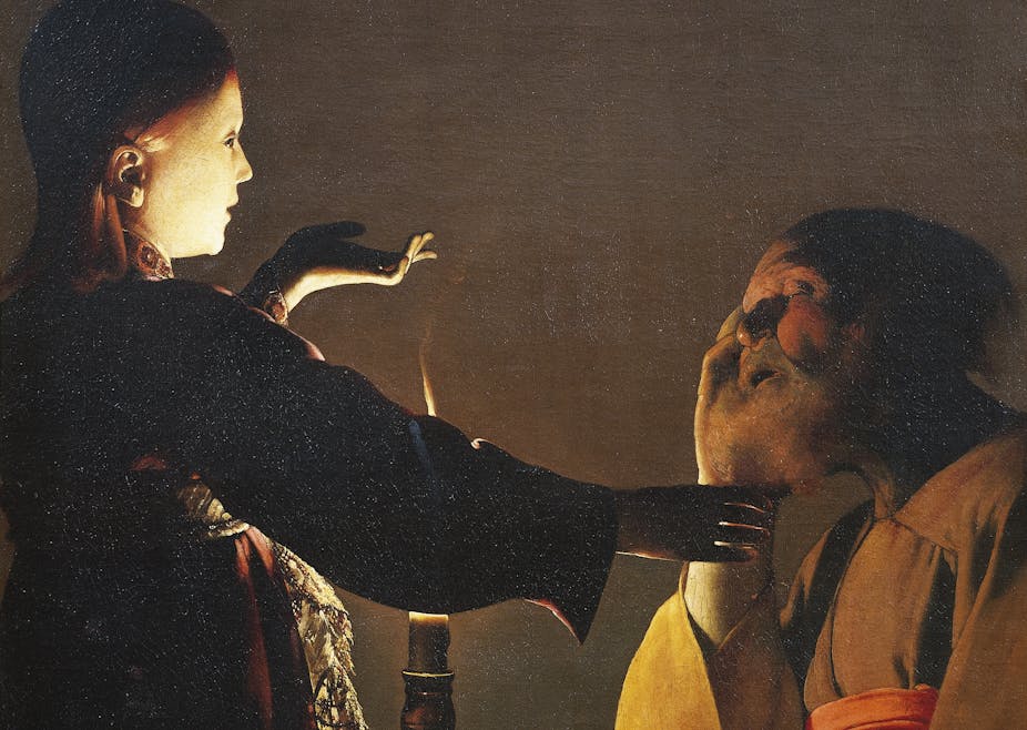 A girl reaches out to touch an elderly man who's sleeping.