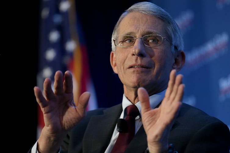 Dr. Fauci in front of an American flag.