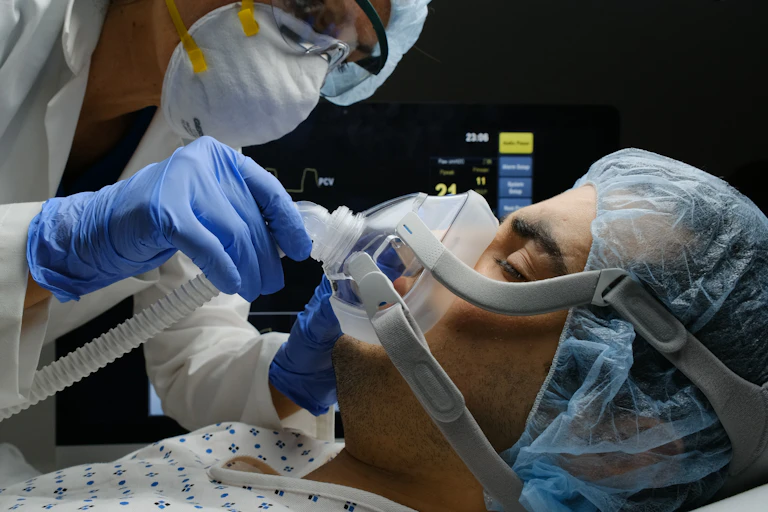 A clinician adjusts a patient's oxygen mask