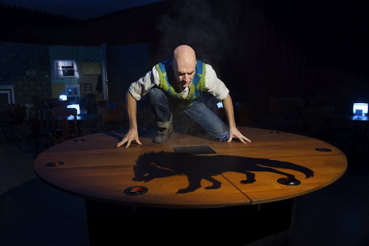 Production image: a man looks at the shadow of a dog.