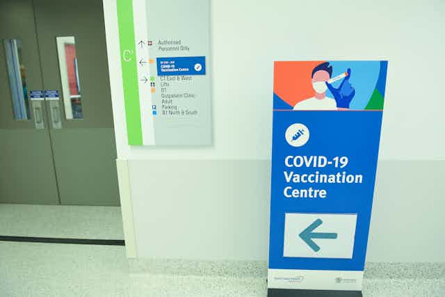 A sign points to 'COVID-19 Vaccination Centre.'