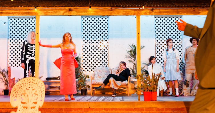 In fancy dress, the family stand on the porch.