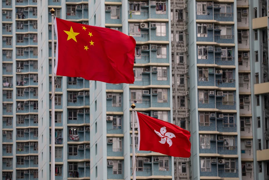 Chinese flag flies above Hong Kong flag in the Hong Kong financial district.
