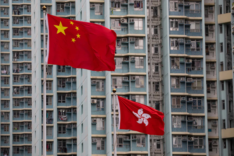 Chinese flag flies above Hong Kong flag in the Hong Kong financial district.