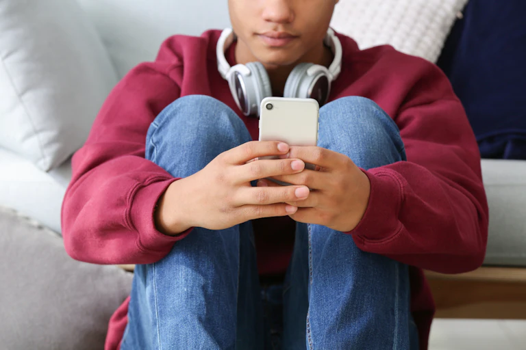 A teenage boy using a mobile phone.