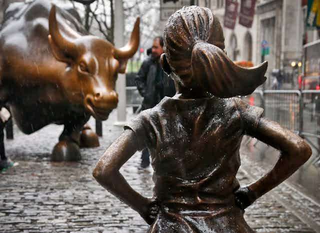 The Fearless Girl statue faces the Charging Bull statue.