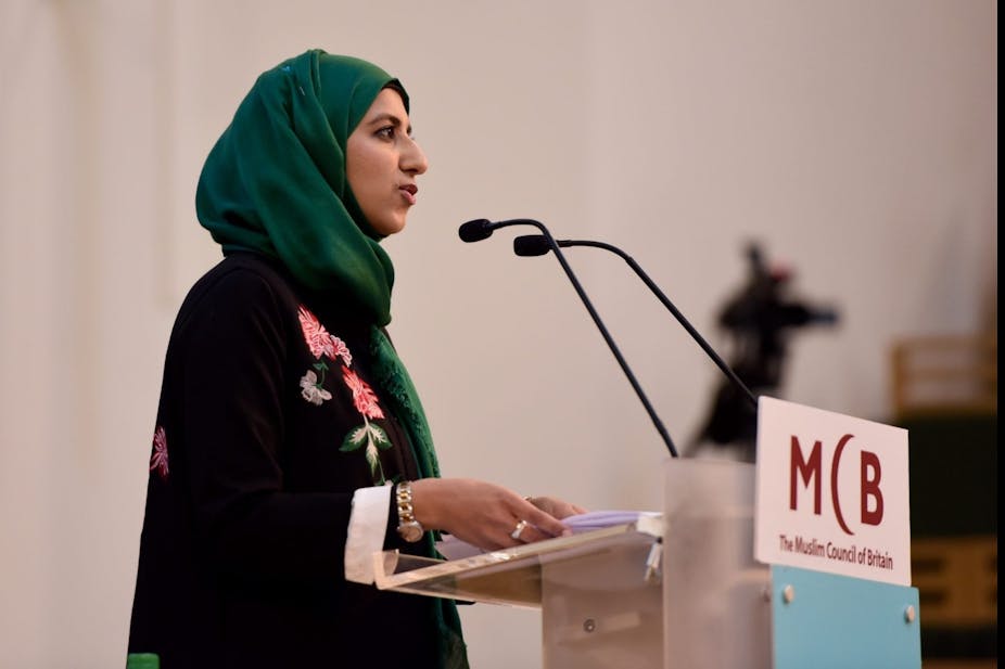 Woman giving speech at a podium with a logo that reads: MCB The Muslim Council of Britain