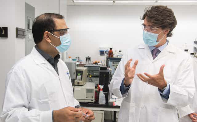 A scientist with Justin Trudeau in facemaks.s