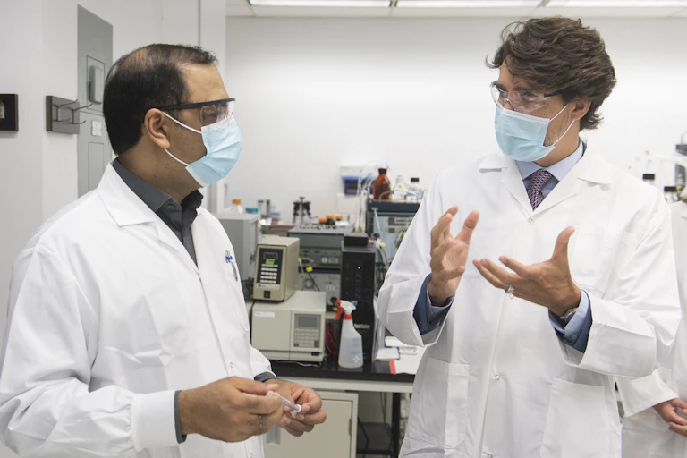 A scientist with Justin Trudeau in facemaks.s