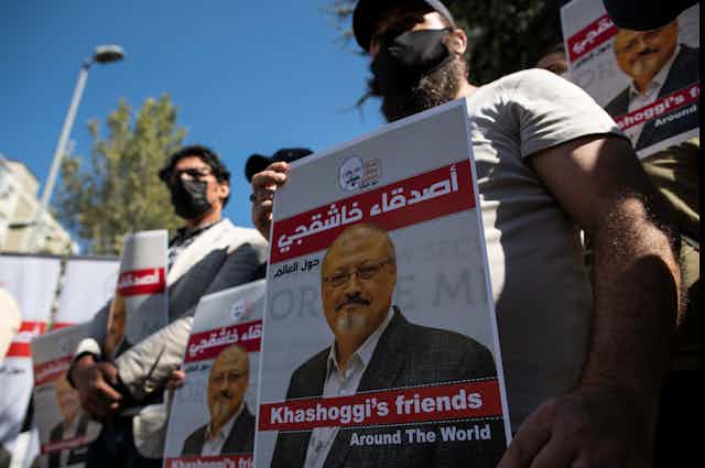 Protesters with a poster in Arabic and English about murdered dissident journalist Jamal Khashoggi.