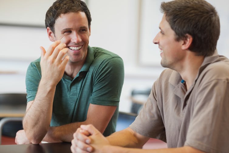 Two young male students smiling and chatting